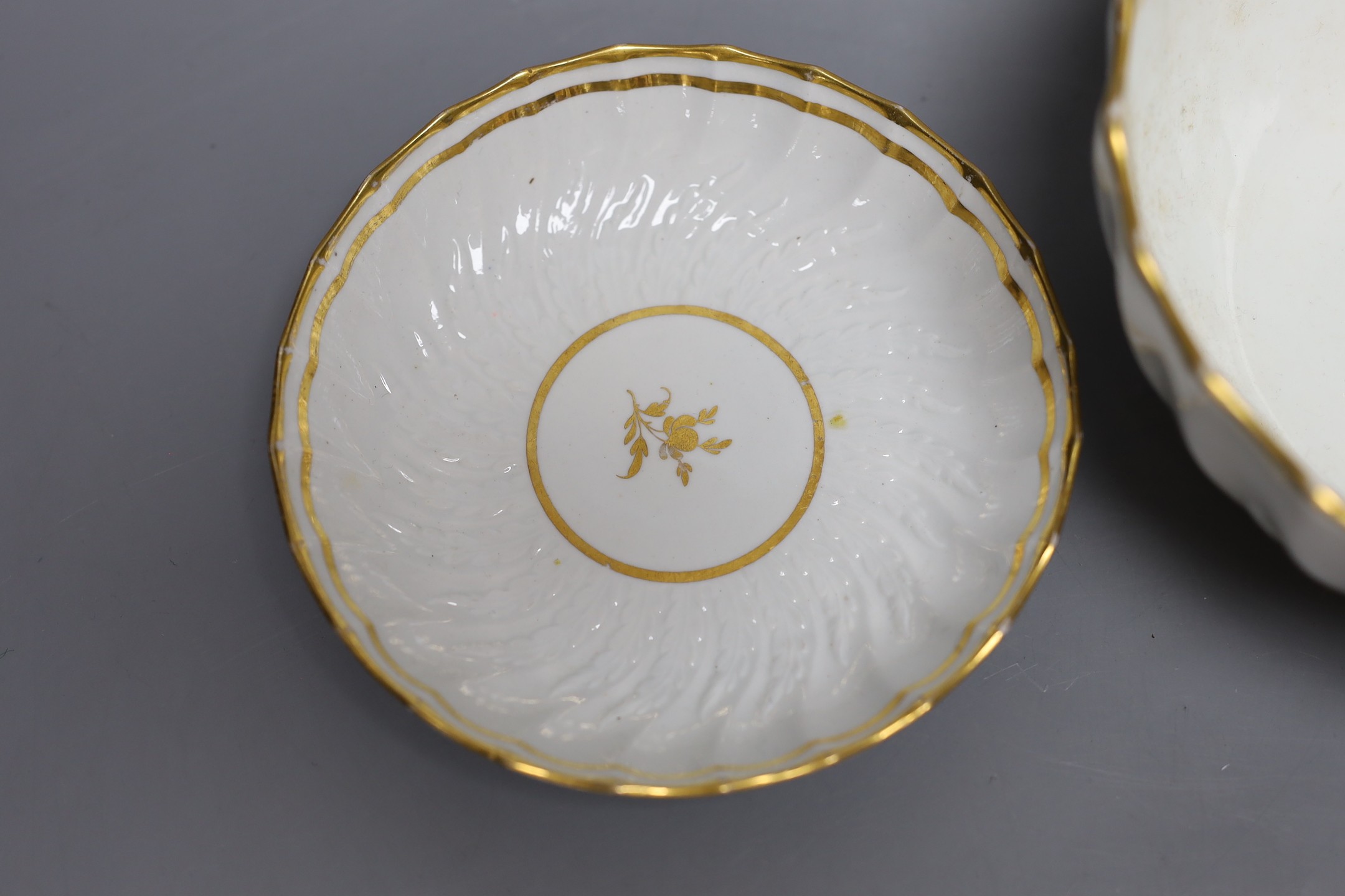 A Neale and Co rare teabowl and saucer and a matching bowl, each piece with acanthus leaf and spirally shanked moulding, the interiors with a gilt floret design, within gilt line borders, for a similar teabowl see Michae